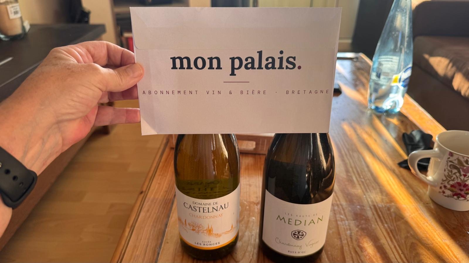 Boîte Mon Palais reçue par un abonné, avec deux bouteilles de vin blanc et la carte de bienvenue